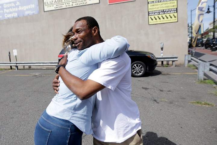 Lee Parker, right, is hugged by Raiza Acosta who wanted to thank Parker for finding a bomb near a trash can, Wednesday, Sept. 21, 2016, in Elizabeth, N.J. Authorities say Parker and a friend contacted police after finding the bag near the Elizabeth train station Sunday night. Federal investigators say the bag was left by New York-region bombing suspect Ahmad Khan Rahami.
