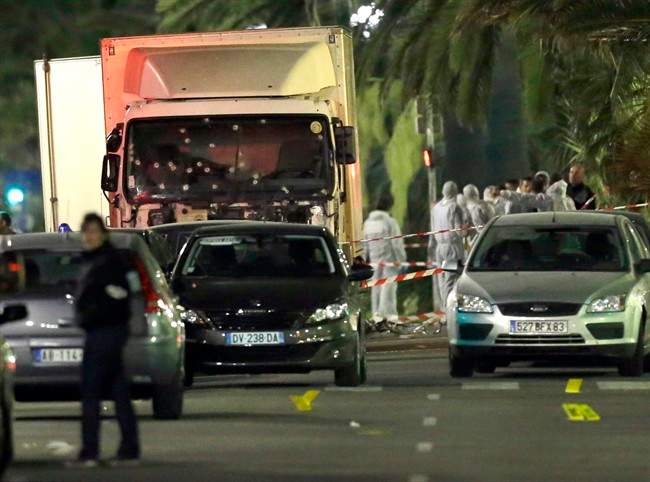 FILE - In this July 15, 2016 file photo, forensic officers stand near a truck with its windscreen riddled with bullets that plowed through a crowd of revelers who'd gathered to watch the fireworks in the French resort city of Nice, southern France. French authorities have made eight new arrests in connection with the Bastille Day truck attack in Nice that left 86 people dead, the Paris prosecutor's office said on Tuesday, Sept. 20, 2016. (AP Photo/Claude Paris, File).