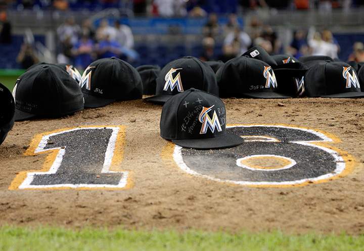 Miami Marlins ball caps left by the players sit on the pitching mound with the number 16 in honour of pitcher Jose Fernandez after a baseball game against the New York Mets, Monday, Sept. 26, 2016, in Miami.