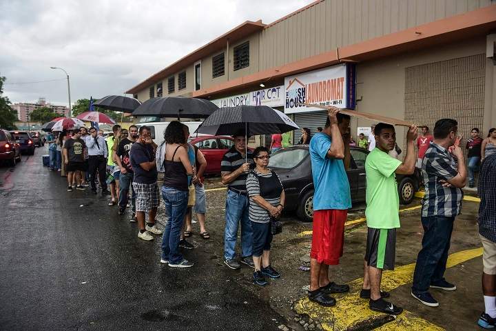People wait in line to buy ice during a massive blackout in San Juan, Puerto Rico, Thursday, September 22, 2016. Puerto Ricans faced another night of darkness Thursday as crews slowly restored electricity a day after a fire at a power plant caused the aging utility grid to fail and blacked out the entire island.