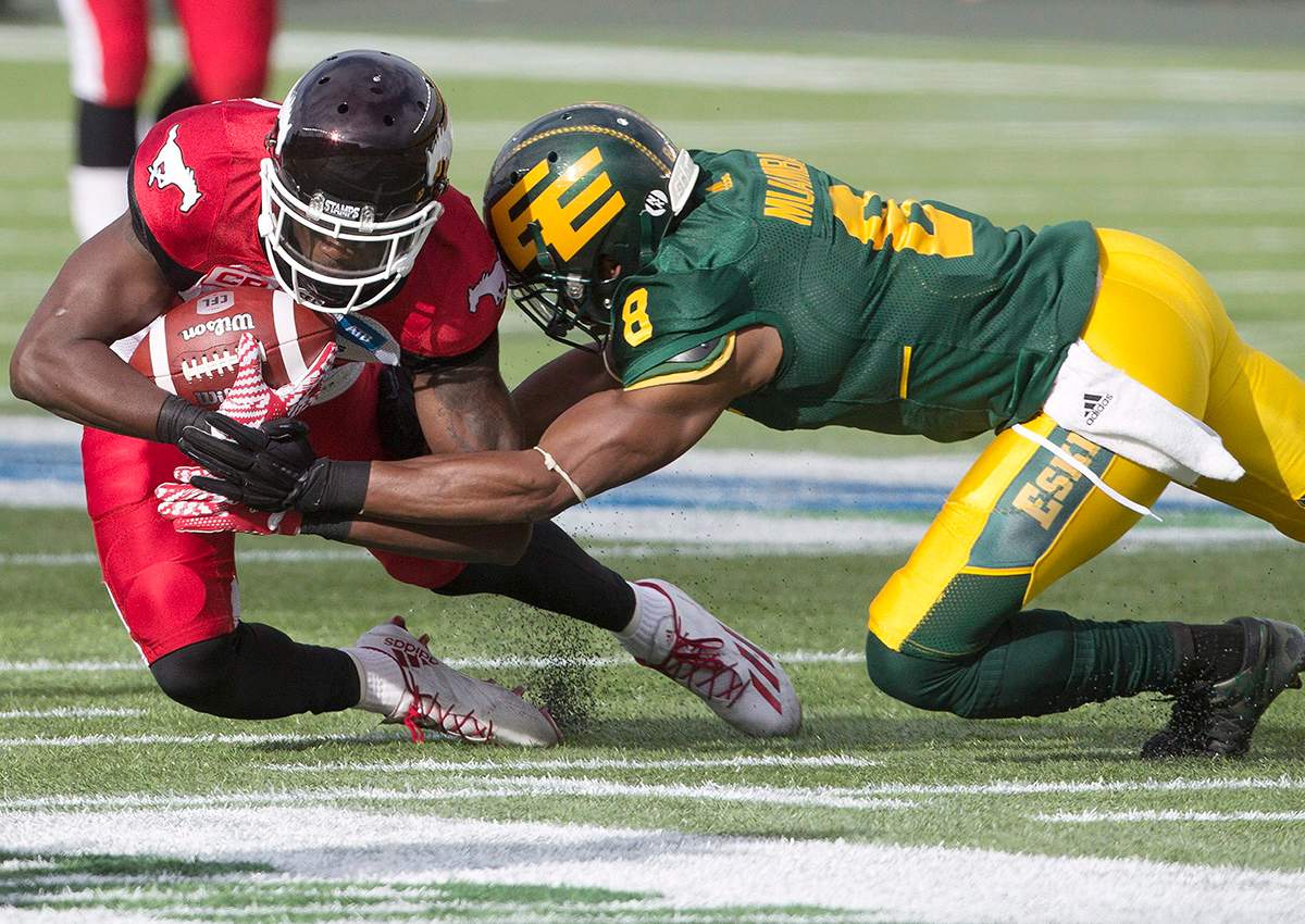 Calgary Stampeders DaVaris Daniels (89) is tackled by Edmonton Eskimos Cauchy Muamba (8) during first half CFL action in Edmonton, Alta., on Saturday September 10, 2016.