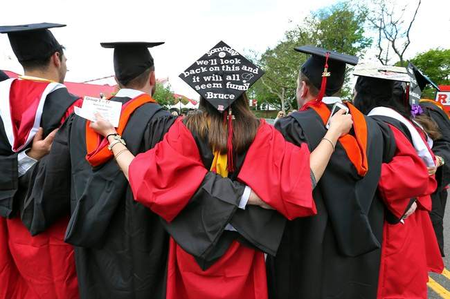 FILE - In this May 15, 2016 file photo, students embrace as they arrive for the Rutgers graduation ceremonies in Piscataway, N.J. 