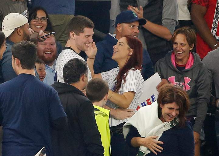 Fans laugh as Andrew Fox and Heather Terwilliger smile during a baseball game between the New York Yankees and the Boston Red Sox at Yankee Stadium in New York, Tuesday, Sept. 27, 2016.