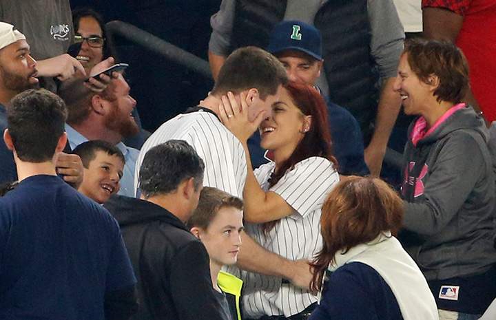 Andrew Fox and Heather Terwilliger embrace after getting engaged during a baseball game between the New York Yankees and the Boston Red Sox in New York, Tuesday, Sept. 27, 2016.