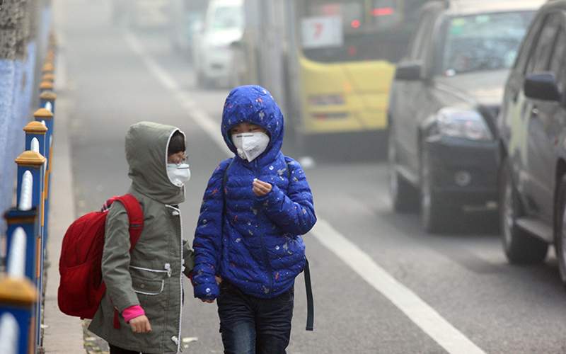 Two children wearing face masks walk in heavy smog on November 3, 2015 in Harbin, Heilongjiang Province of China. 