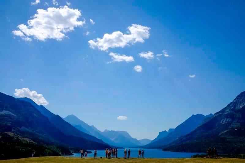 Tourists look out over Waterton Lake in Waterton Lakes National Park, Alta., Tuesday, Aug. 16, 2016.