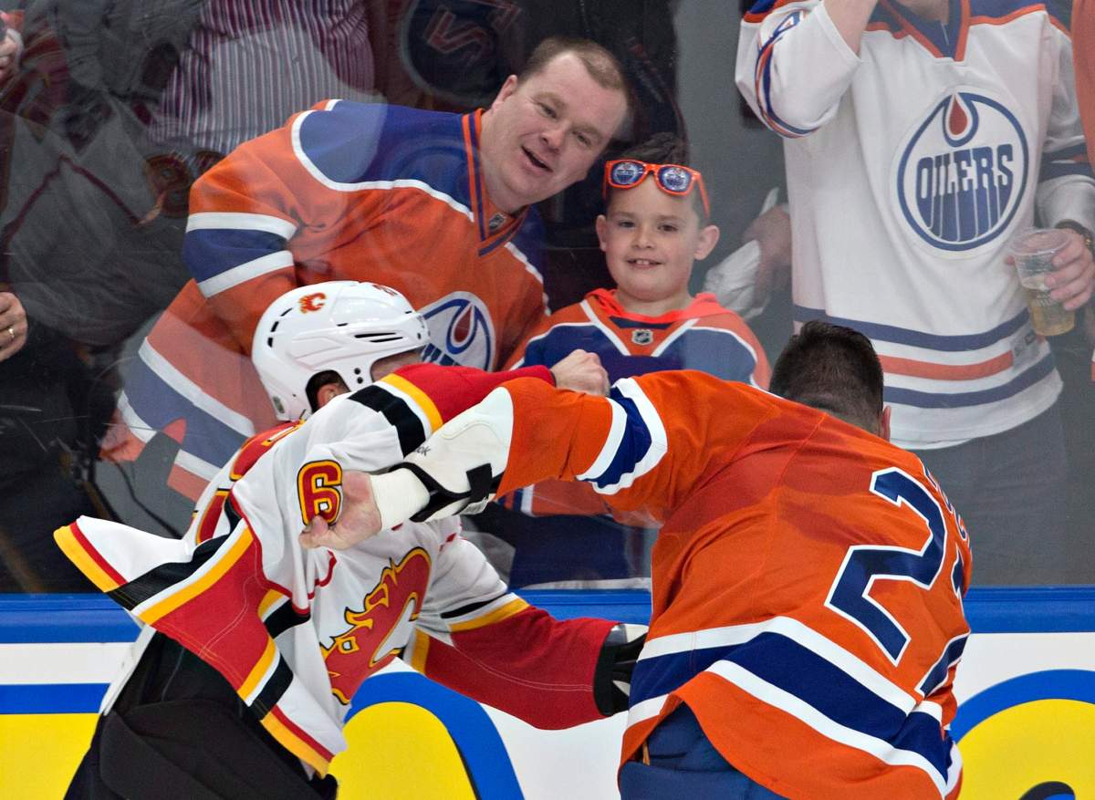 Calgary Flames' Deryk Engelland (29) and Edmonton Oilers' Milan Lucic (27) fight during first period NHL action in Edmonton, Alta., on Wednesday October 12, 2016. 