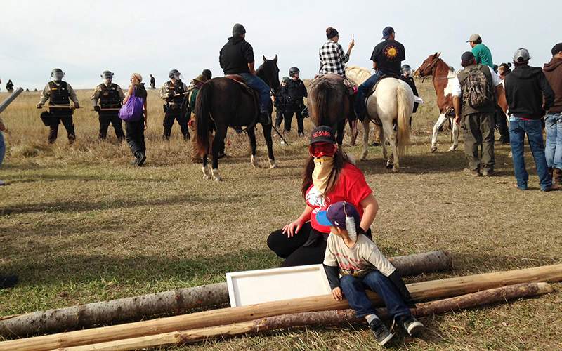 Dakota Access pipeline protesters stand in defiance of law enforcement officers who are trying to force them from a camp on private land in the path of pipeline construction on Thursday, Oct. 27, 2016, near Cannon Ball, N.D. 