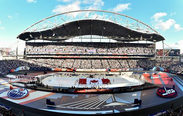 Fans stand for the Canadian national anthem before the matchup between the Winnipeg Jets and the Edmonton Oilers during the 2016 Tim Hortons NHL Heritage Classic at Investors Group Field on Oct. 23, 2016, in Winnipeg, Man.