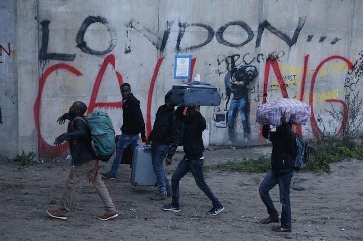 Migrants carry their belongings at the start of their evacuation and transfer to reception centres in France, and the dismantlement of the camp called the “Jungle” in Calais, France, October 24, 2016. REUTERS/Pascal Rossignol