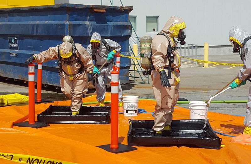 In this June 27, 2016 photo provided by the Royal Canadian Mounted Police, members of the RCMP go through a decontamination procedure in Vancouver after intercepting a package containing approximately 1 kilogram (2.2 pounds) of the powerful opioid carfentanil imported from China. (Royal Canadian Mounted Police via AP)