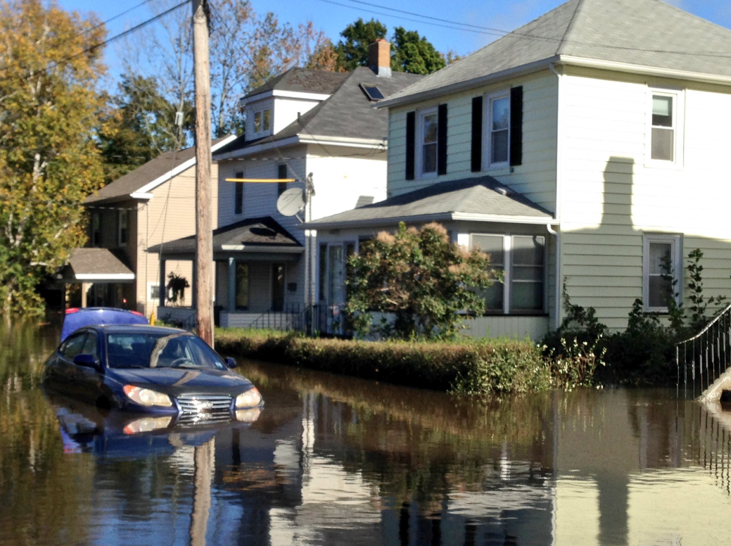 A car is seen partly submerged on a street in Sydney, Cape Breton after torrential rains flooded many parts of the island. 