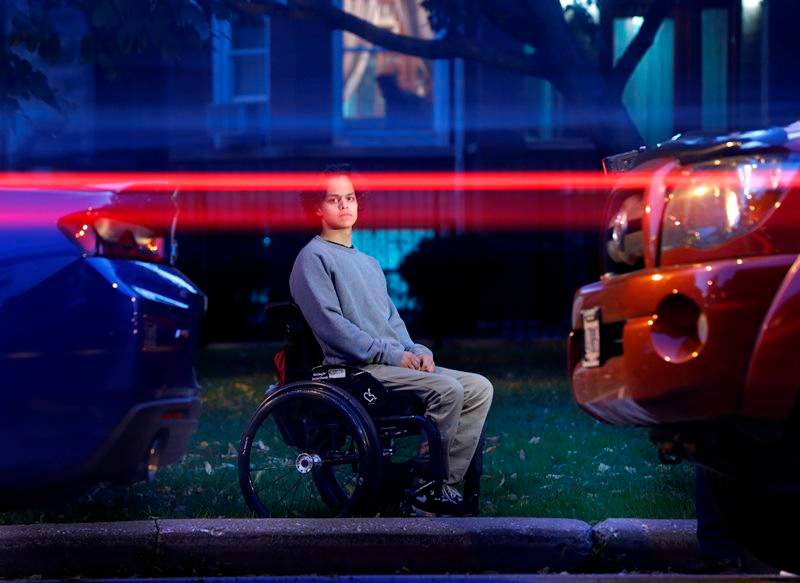 In this Thursday, Oct. 13, 2016 photo, vehicles pass by as Jonathan Annicks poses for a portrait in front of his home, just a few feet from where a gunman shot him while he was inside his brother's parked car in Chicago on April 10. 