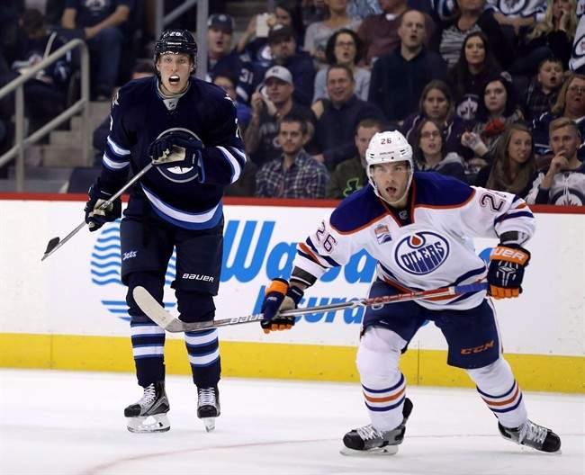 Winnipeg Jets' Patrik Laine (29) watches the puck with Edmonton Oilers' Iiro Pakarinen (26) during second period pre-season NHL hockey in Winnipeg, Friday, September 30, 2016. It's all about the kids this season for the Winnipeg Jets. 