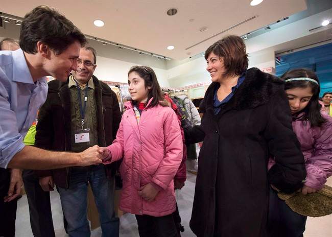 Canadian Prime Minister Justin Trudeau greets newly-arrived Syrian refugees Lucie Garabedian, centre, her father Vanig Garabedian, second left, mother Anjilik Jaghlassian, second right, and sister Anna-Maria Garabedian, right, at Pearson International airport, in Toronto, in a Dec. 11, 2015, file photo.