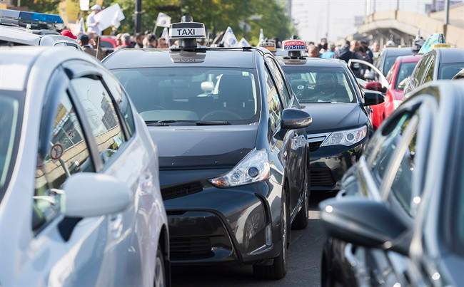 Taxi cabs block a street during a demonstration opposing the presence of Uber in the province of Quebec.