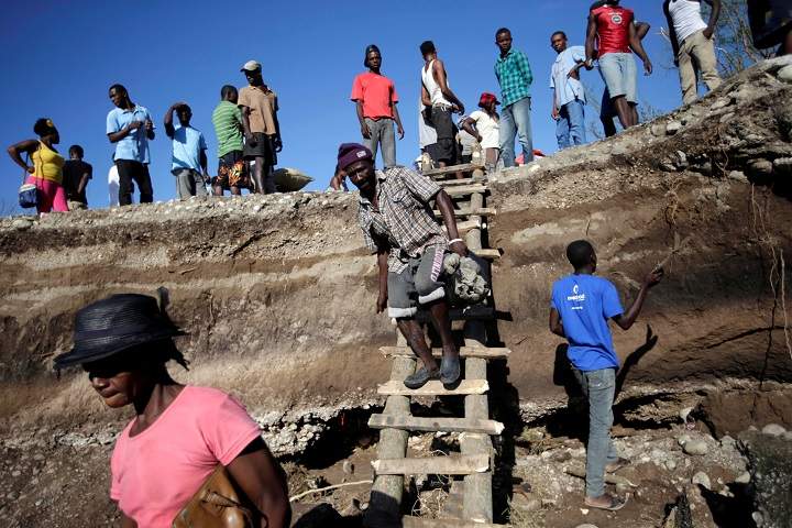People use a handmade ladder after the bridge has been destroyed by Hurricane Matthew in Chantal, Haiti October 7, 2016. REUTERS/Andres Martinez Casares
