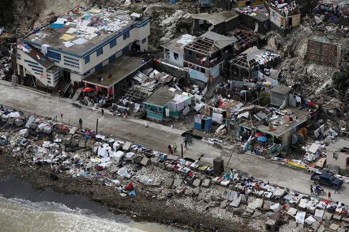 People walk next to destroyed houses after Hurricane Matthew hit Jeremie, Haiti, October 6, 2016. REUTERS/Carlos Garcia Rawlins