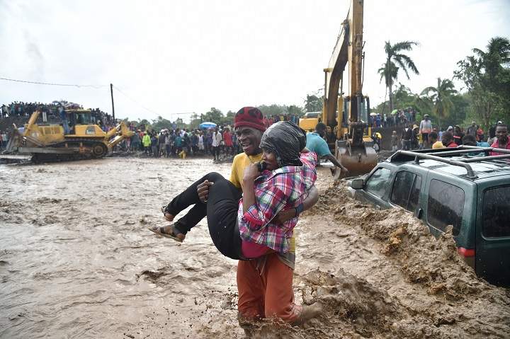 A woman is carried across the river La Digue in Petit Goave where the bridge collapsed during the rains of the Hurricane Matthew, southwest of Port-au-Prince, October 5, 2016.