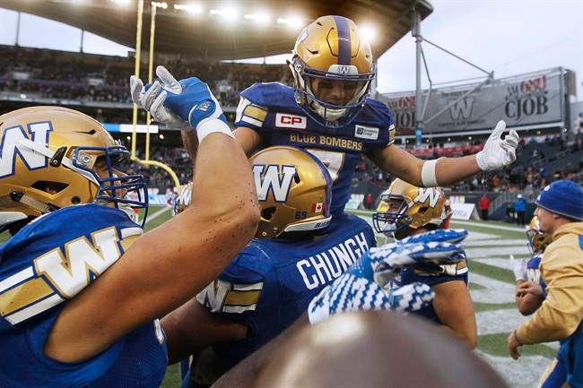 Winnipeg Blue Bombers players raise Weston Dressler (7) after he ran around the end zone burning off precious time in the dying seconds of the second half of CFL action against the B.C. Lions in Winnipeg Saturday, October 8, 2016. 