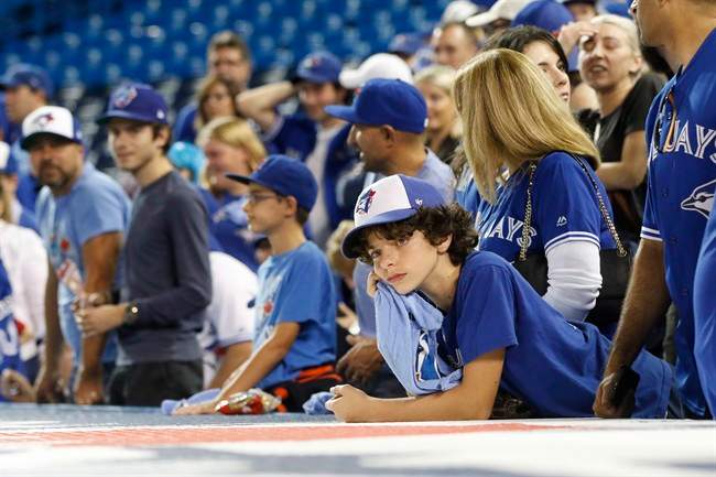 Toronto Blue Jays fans look on after the Cleveland Indians defeated the Blue Jays in game five American League Championship Series baseball action in Toronto on Wednesday, October 19, 2016.