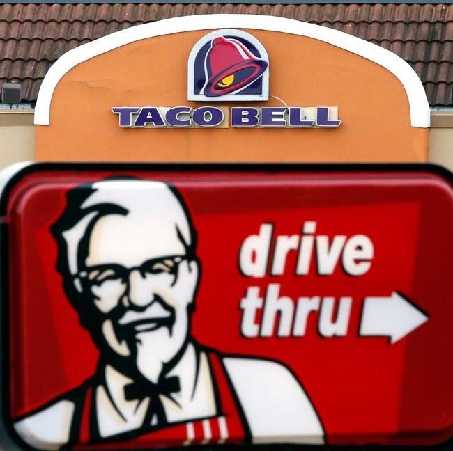 FILE - This Jan. 31, 2014, file photo, shows a Taco Bell facade behind a KFC drive-thru sign in Saugus, Mass. 
