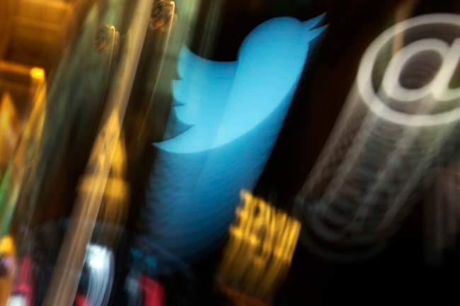 In this  Nov. 6, 2013, file photo, the Twitter logo appears on an updated phone post on the floor of the New York Stock Exchange. 