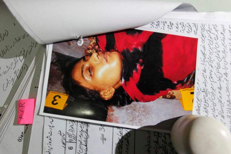In this photo taken on Thursday, Sept. 1, 2016, a picture of Tasleem, who was shot by her brother, is seen with records at police headquarters in Lahore, Pakistan.