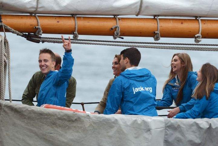 A young crew member gestures to the camera as the Duke and Duchess of Cambridge help to hoist the sails on a tall ship in Victoria on Saturday, Oct. 1, 2016.