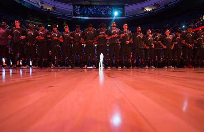 Toronto Raptors players lock arms during the singing of the national anthems before a pre-season NBA basketball game against the Golden State Warriors in Vancouver, B.C., on Saturday October 1, 2016.