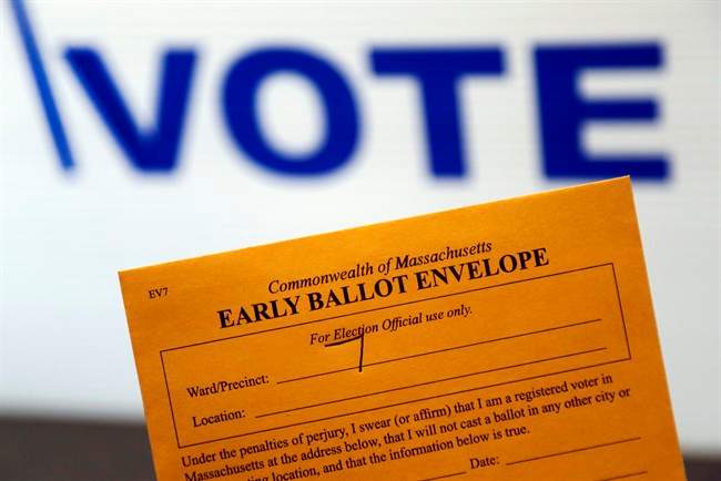 In this Oct. 24, 2016, photo, an early ballot envelope is held at town hall in North Andover, Mass. The millions of votes that have been cast already in the U.S. presidential election point to an advantage for Hillary Clinton in critical battleground states, as well as signs of strength in traditionally Republican territory. (AP Photo/Elise Amendola).