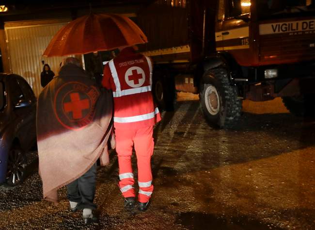 Residents of the small town of Visso in central Italy, early Thursday, Oct 27, 2016, are assisted by the Italian red Cross after a 5.9 earthquake destroyed part of their neighborhood. A pair of strong aftershocks shook central Italy late Wednesday, crumbling churches and buildings, knocking out power and sending panicked residents into the rain-drenched streets just two months after a powerful earthquake killed nearly 300 people. (AP Photo/Alessandra Tarantino).