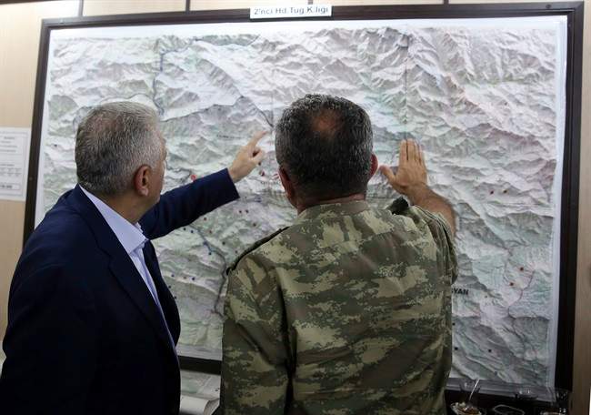 In this Monday, Sept. 5, 2016 photo, an army commander informs Turkey's Prime Minister Binali Yildirim, left, on a Turkey-Iraq border map, in Cukurca, Turkey. Iraq's Foreign Ministry has summoned Turkeys' ambassador to Baghdad over "provocative" comments by Turkish Prime Minister Binali Yildirim about the planned operation to dislodge Islamic State militants from the city of Mosul.