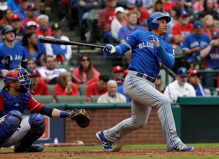 Texas Rangers catcher Jonathan Lucroy, left, and Toronto Blue Jays' Ezequiel Carrera, right, watch the flight of Carrera's solo home run in the fifth inning of Game 2 of baseball's American League Division Series, Friday, Oct. 7, 2016, in Arlington, Texas. 
