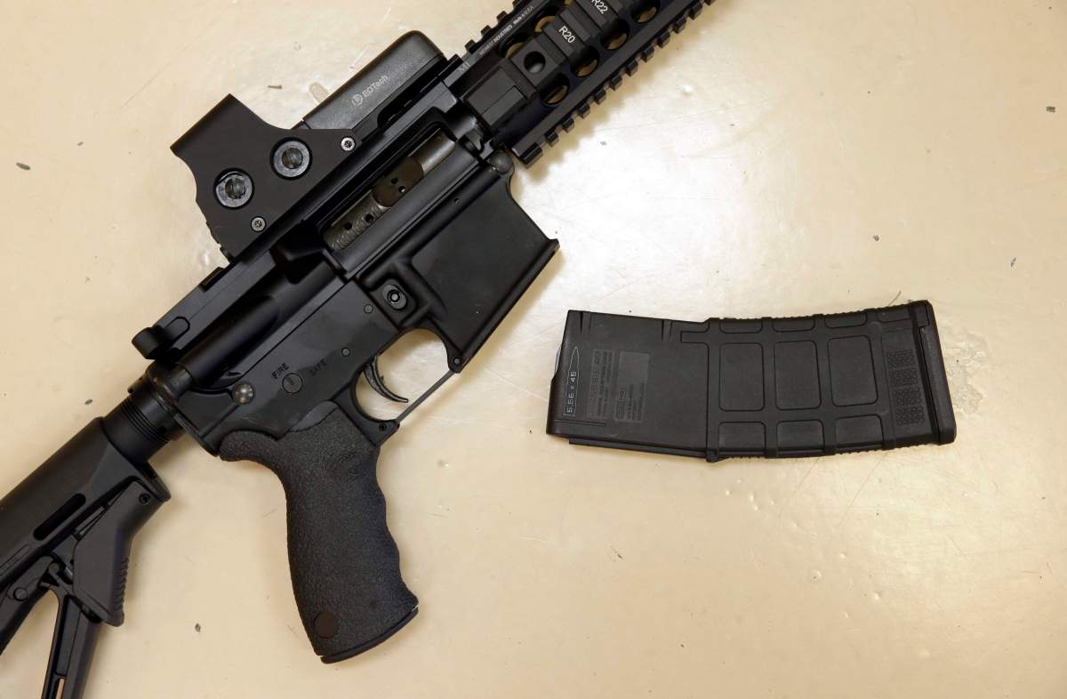FILE - This Oct. 3, 2013 file photo shows a custom-made semi-automatic hunting rifle with a high-capacity detachable magazine is displayed at a gun store in Rockin, Calif. California voters are considering expanding some of the nation's toughest gun control measures nearly a year after the terrorist shootings in San Bernardino. Proposition 63 on the November ballot would outlaw possession of large-capacity ammunition magazines, require permits to buy ammunition and extend California's unique program that allows authorities to seize firearms from owners who bought guns legally but are no longer allowed to own them. (AP Photo/Rich Pedroncelli, File).