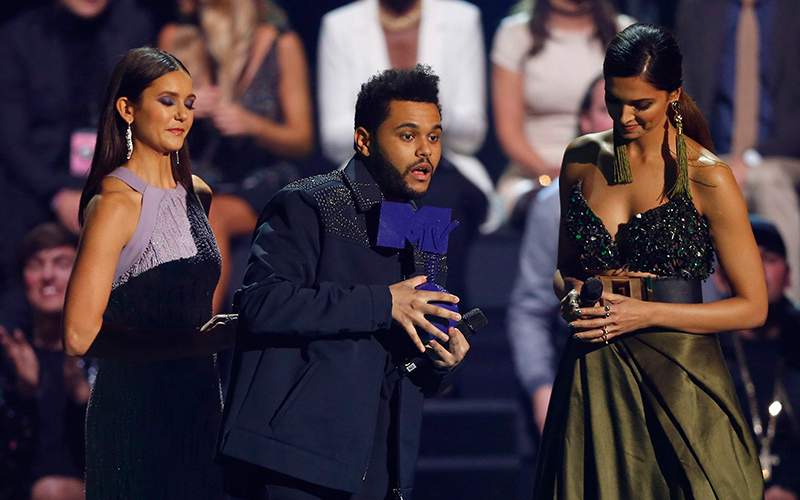 The Weeknd, centre, receives the Best Video Award from Nina Dobrev, left and Deepika Padukone, during the MTV European Music Awards 2016, in Rotterdam, Netherlands, Sunday, Nov. 6, 2016. 