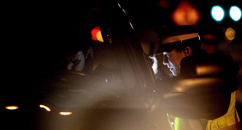 A police officer speaks with a driver while looking for impaired drivers during a roadside check in Surrey, B.C. in this file image. 