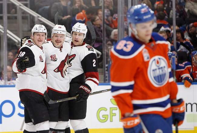 Arizona Coyotes' Christian Dvorak (18), Jamie McGinn (88) and Luke Schenn (2) celebrate a goal as Edmonton Oilers' Matthew Benning (83) skates past during third period NHL action in Edmonton, Alta., on Sunday November 27, 2016.