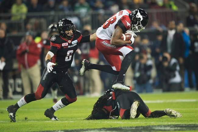 Calgary Stampeders slotback Kamar Jorden leaps over Ottawa Redblacks defensive back Abdul Kanneh as he breaks away from defensive back Antoine Pruneau during first quarter CFL Grey Cup action Sunday, November 27, 2016 in Toronto. 