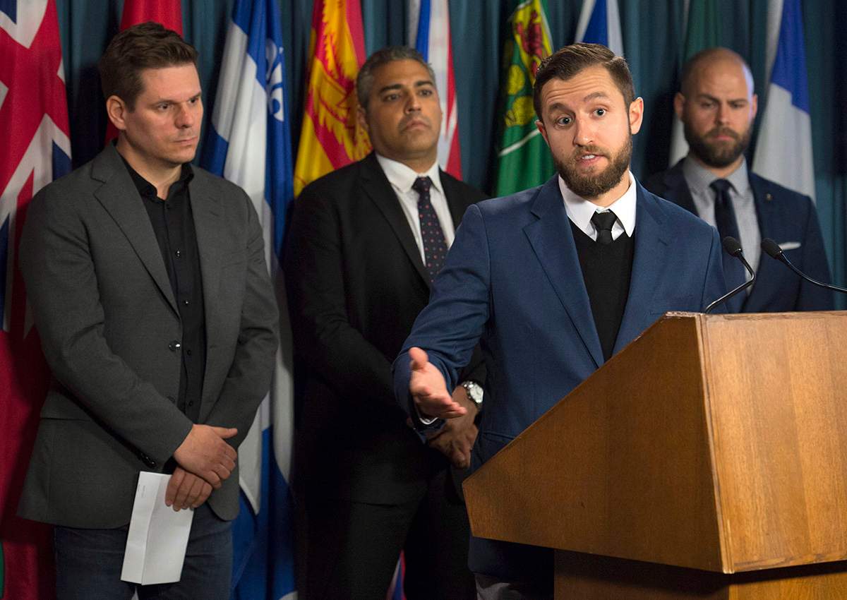 La Presse journalist Patrick Lagace (left), journalist Mohamed Fahmy, and Executive Director of Canadian Journalists for Free Expression Tom Henheffer (right) listen to VICE News journalist Ben Makuch speak about his experiences during a news conference on police surveillance and greater protection for journalists in Ottawa, Wednesday November 16, 2016.