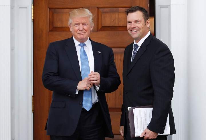 President-elect Donald Trump greets Kansas Secretary of State, Kris Kobach, at the Trump National Golf Club Bedminster clubhouse, Sunday, Nov. 20, 2016, in Bedminster, N.J. The documents Kobach is holding appear to outline his plan for the Department of Homeland Security.