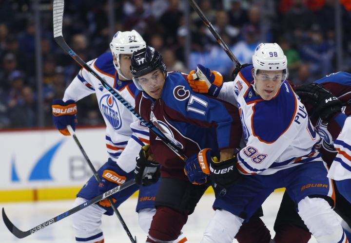 Colorado Avalanche right wing Rene Bourque, center, fights while pursuing the puck with Edmonton Oilers right wing Jesse Puljujarvi, right, of Sweden, and Edmonton Oilers left wing Milan Lucic in the first period of an NHL hockey game, Wednesday, Nov. 23, 2016, in Denver. 