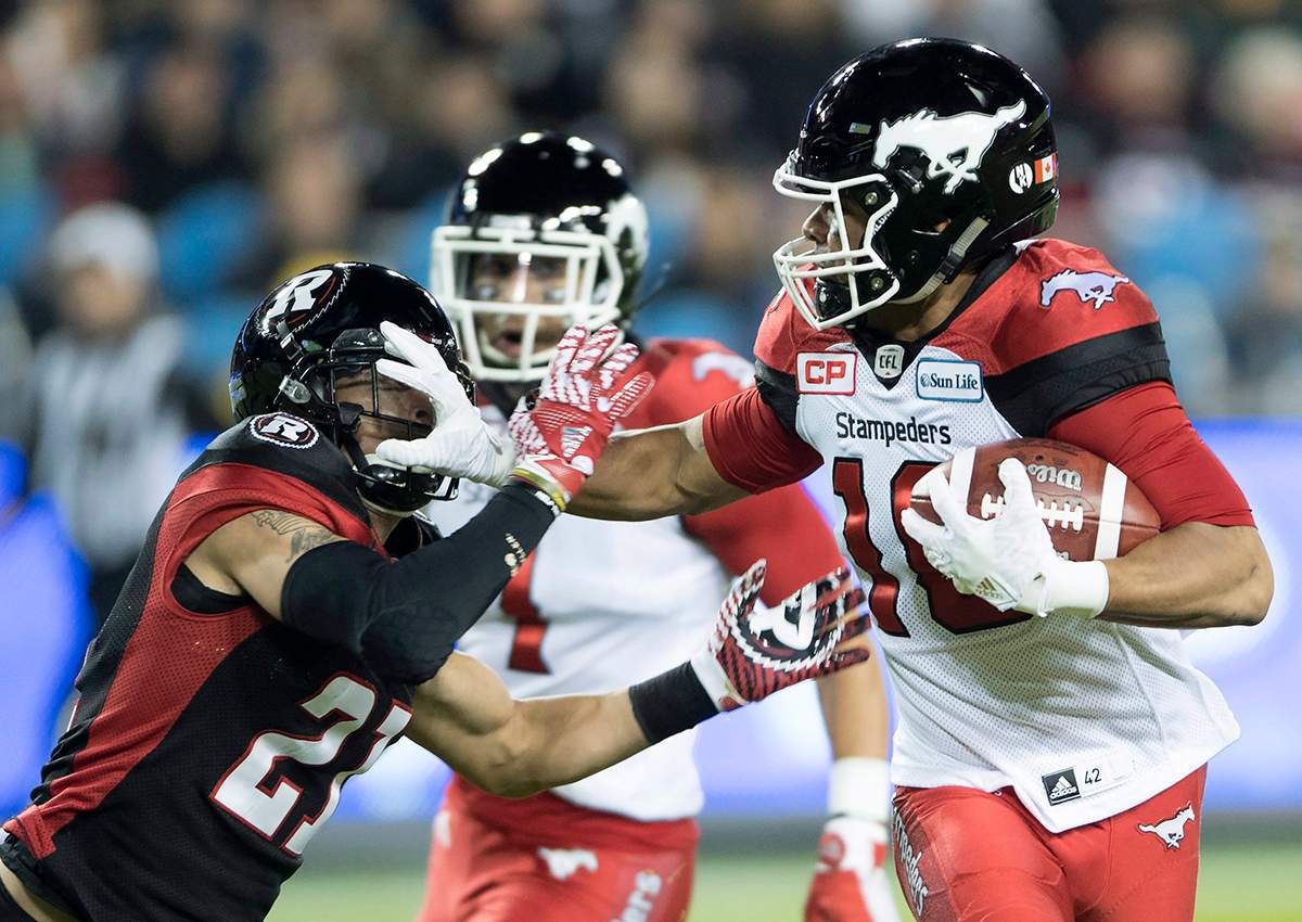 Calgary Stampeders slotback Marquay McDaniel fends off Ottawa Redblacks cornerback Mitchell White during first quarter CFL Grey Cup action, Sunday, November 27, 2016 in Toronto. 