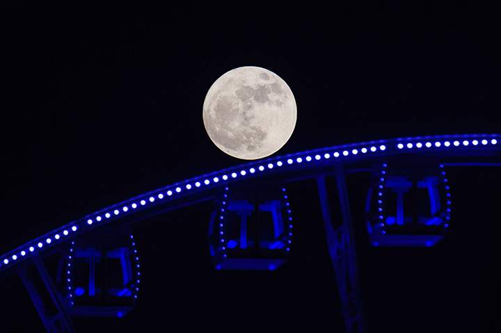 A supermoon is seen rising beyond a Ferris wheel in Hong Kong on November 14, 2016.