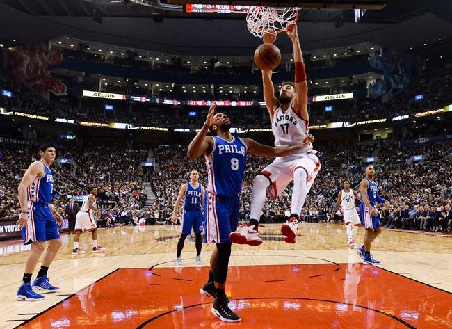 Toronto Raptors centre Jonas Valanciunas (17) slam dunks the ball past Philadelphia 76ers centre Jahlil Okafor (8) during first half NBA basketball action in Toronto on Monday, November 28, 2016. THE CANADIAN PRESS/Nathan Denette.