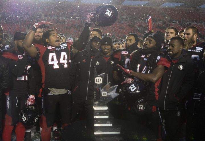 Ottawa Redblacks players celebrate in front of the Eastern Division trophy after defeating the Edmonton Eskimos 35-23 following the CFL Eastern Final, in Ottawa on Sunday, November 20, 2016. 