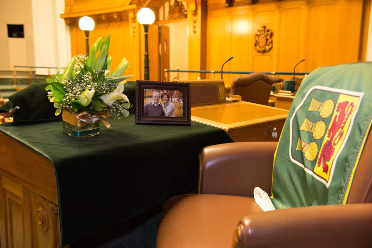 Roger Parent’s desk is draped with the provincial flag, flowers, and a picture of him and his wife.