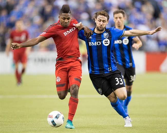 Montreal Impact midfielder Marco Donadel (33) and Toronto FC's Armando Cooper, left, battle for the ball during first half action in the first leg of the MLS Eastern Conference final at the Olympic Stadium in Montreal, Tuesday, November 22, 2016. THE CANADIAN PRESS/Ryan Remiorz.