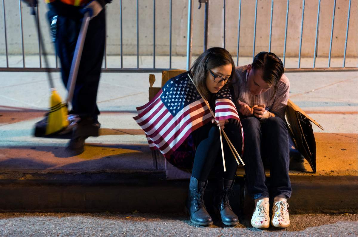 People sit outside the Jacob Javits Center waiting for election results following a rally for Democratic presidential candidate Hillary Clinton in New York Wednesday, Nov. 9, 2016. (AP Photo/Craig Ruttle)