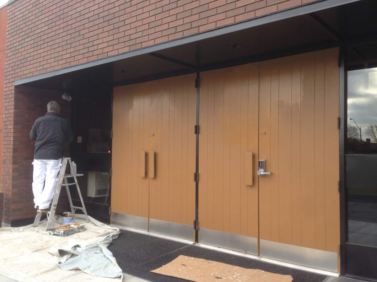 Spray painted swastikas are cleaned from the doors of Congregation Machzikei Hadas, an Ottawa Synagogue, on Thursday, November 17, 2016.